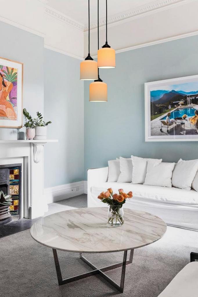 Three light pendant with ceramic shades and round cords in living room