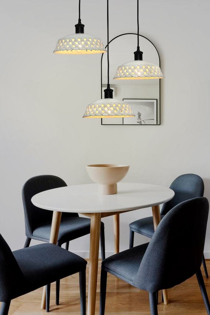 Three light pendant with white ceramic shades over dining table