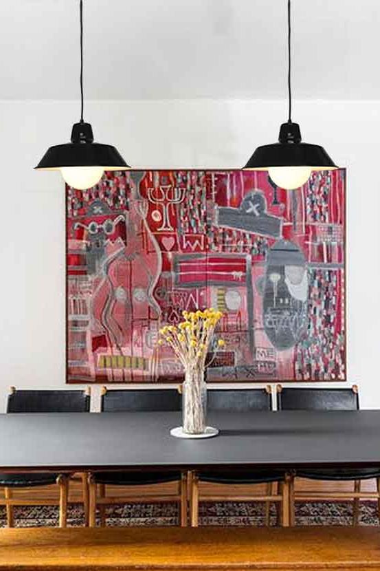 Two black pendant lights with opal glass ball over dining table.