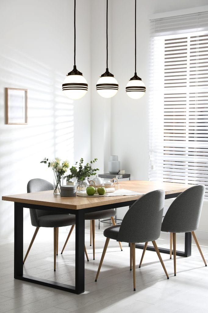 Glass ball liner pendant over a kitchen table setting 