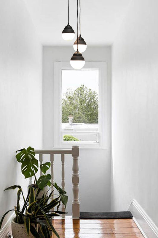 3 Glass pendant lights over stairs.