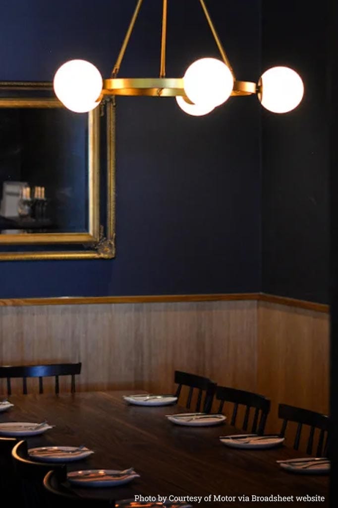 Bonnie Lodge Chandelier Gold over a restaurant dining table.