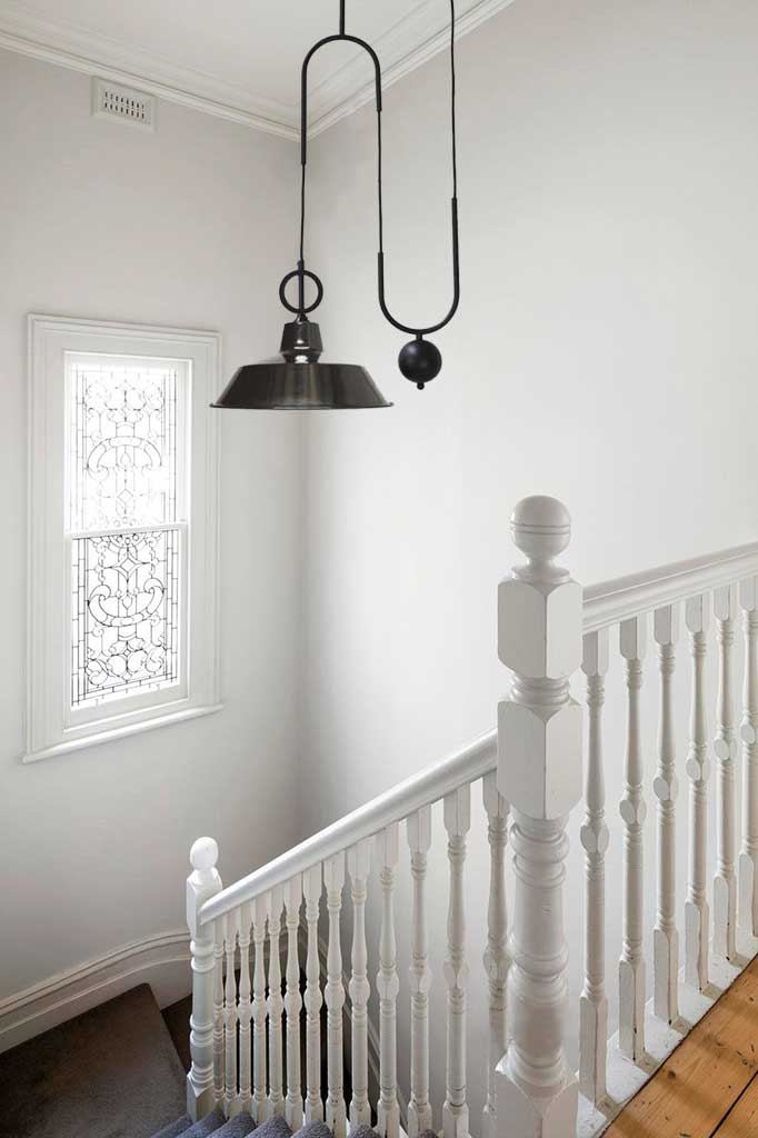 Black factory pulley pendant over stairs.