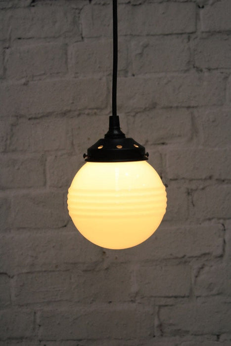 Pendant light with ridged opal glass shade and black round cord