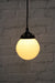 Pendant light with ridged opal glass shade and black round cord