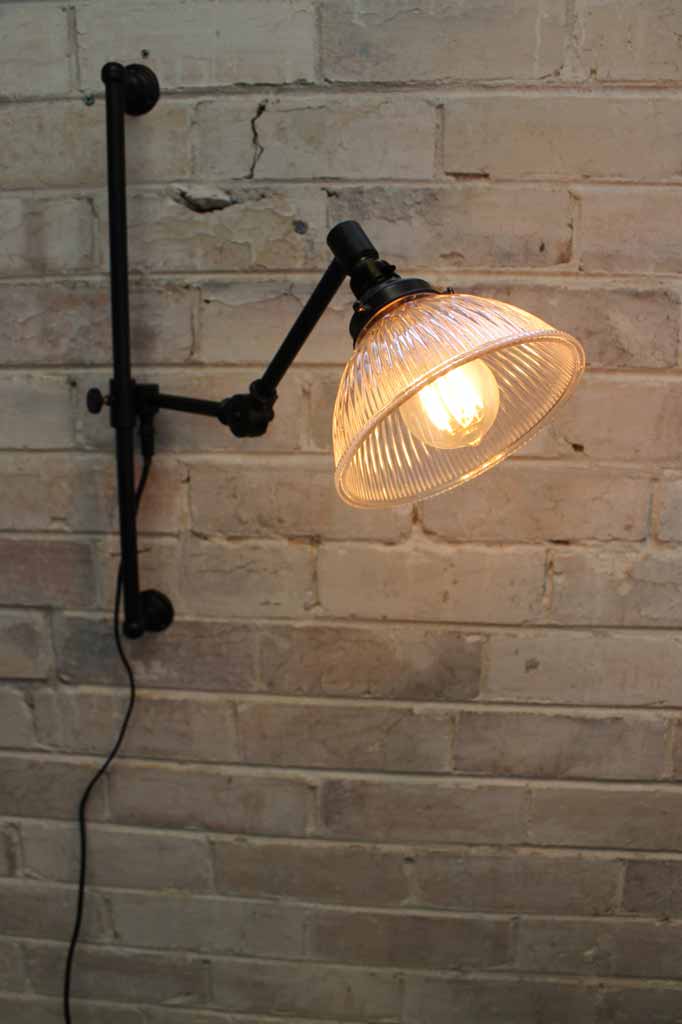 Black metal swing arm wall light with glass shade