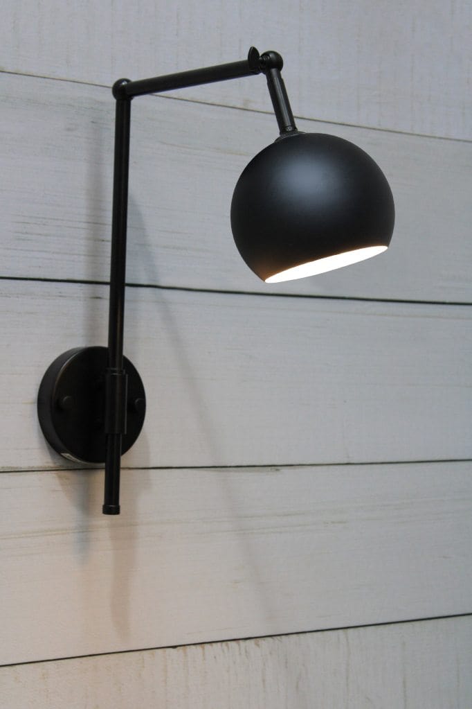 Black swivel wall light with round black shade