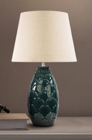 Table lamp with dark green base and tapered ivory shade