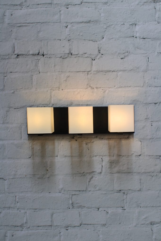 Three light wall light with frosted glass shades and black base