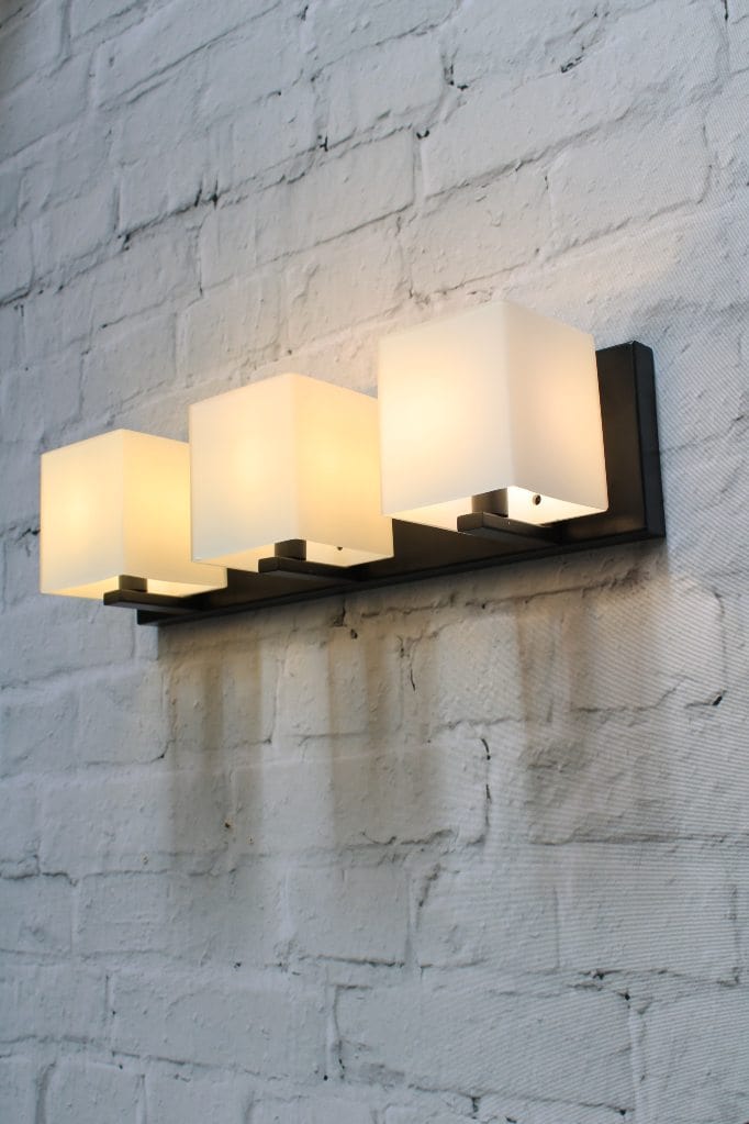 Three light wall light with frosted glass shades and black base