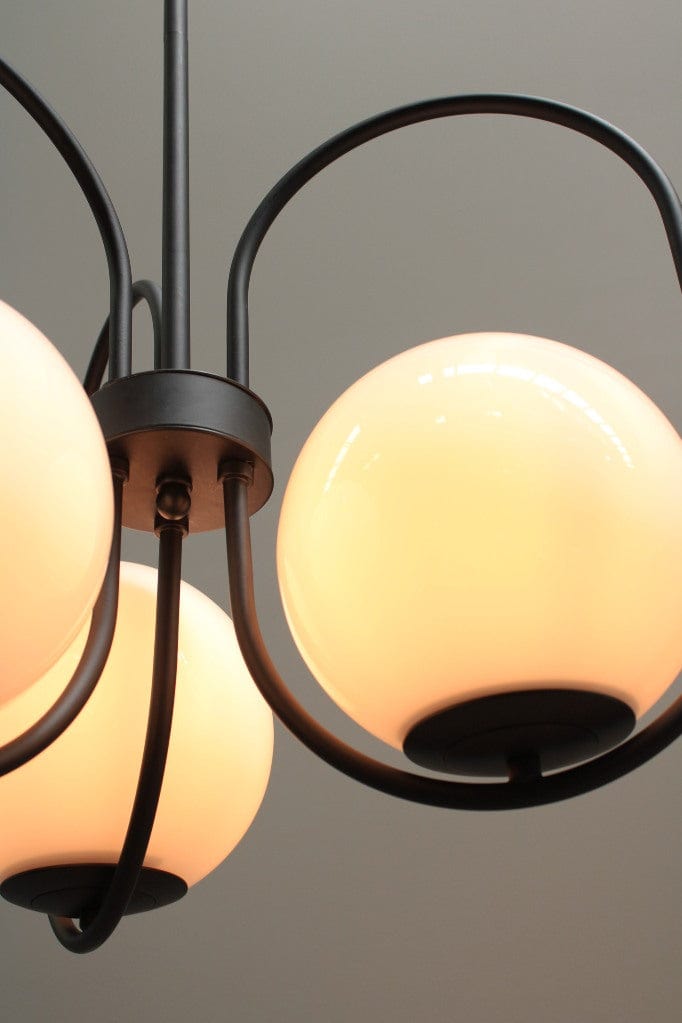 Three light pendant with glass ball shades and black finish metalware, detail of opal gloss shade