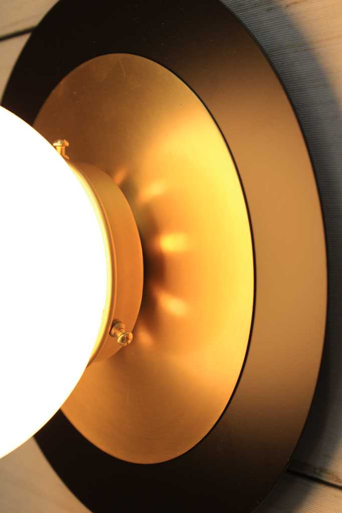 Glass Ball Disc Wall Light close up - small opal shade with large black disc with small brass disc