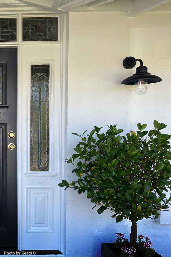 Rustic outdoor steel wall light in the front porch door.