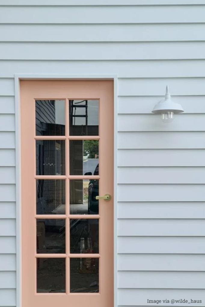 Rustic barn-style white wall light at the front door.