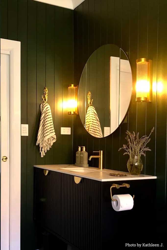 glass rod wall light in gold finish in a bathroom