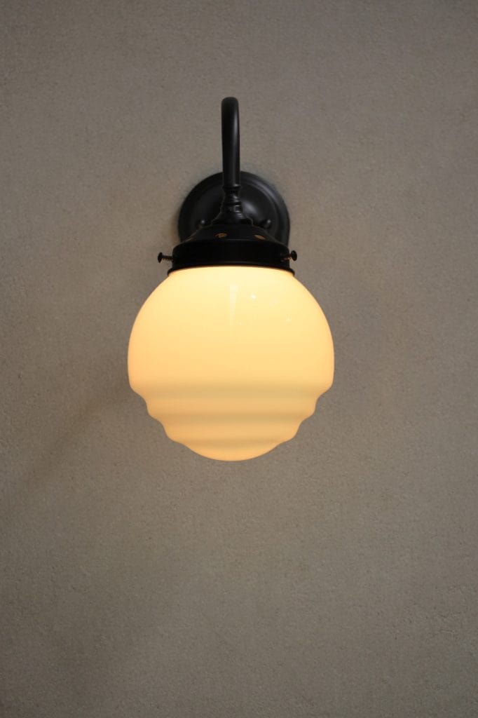 Black wall light with rippled opal shade