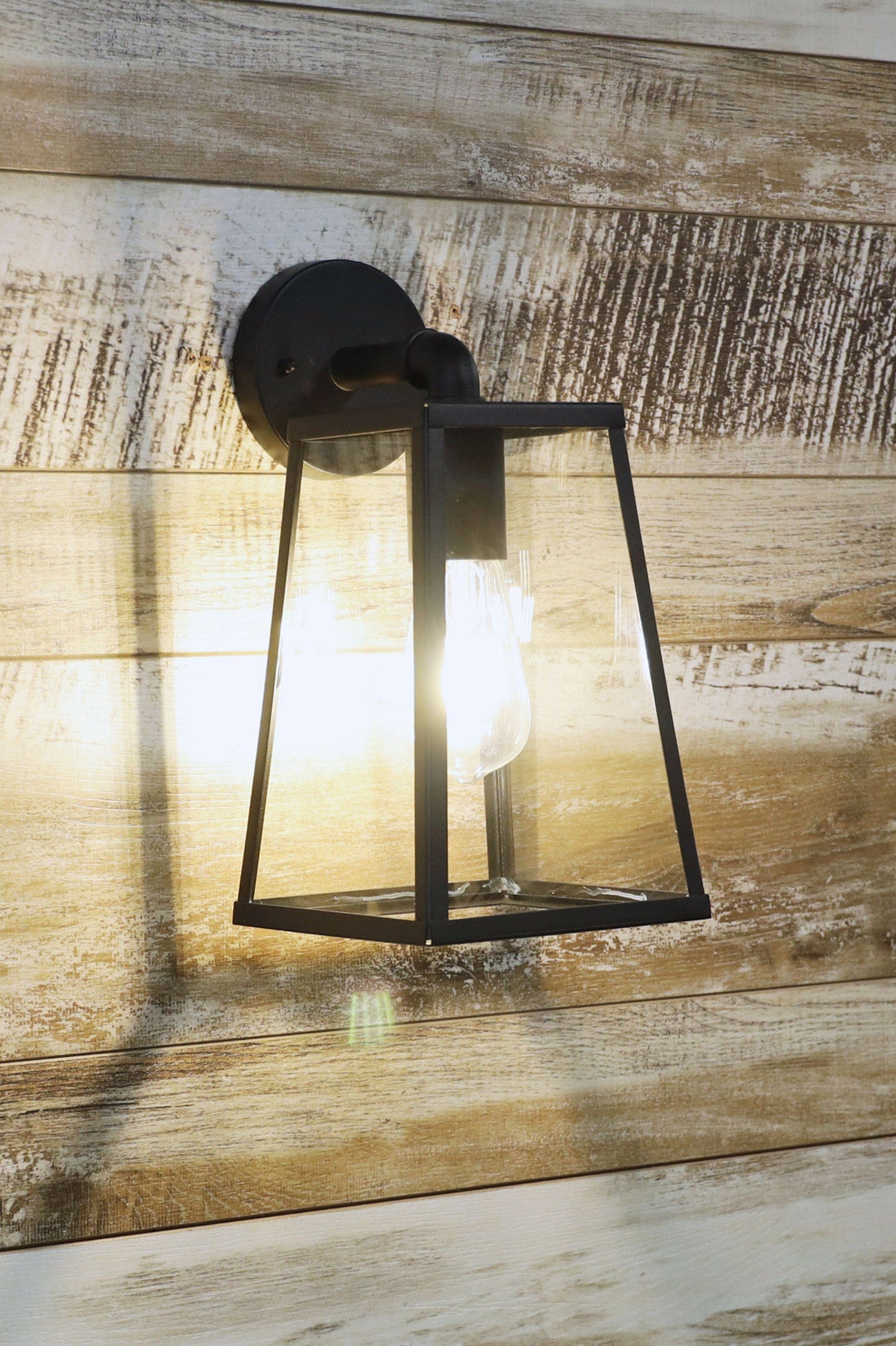 Outdoor Black glass trapeze outdoor wall light on a wooden background