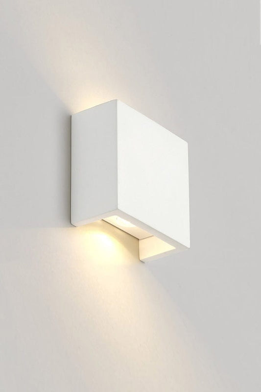 Up and down white rectangular wall light affixed on wall and lit up. 