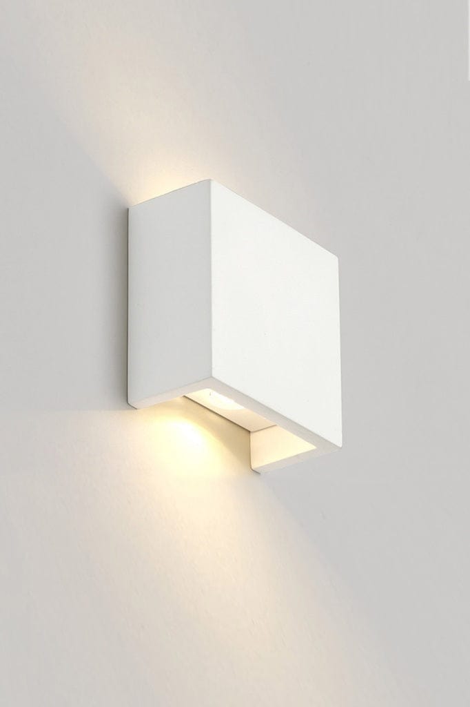 Up and down white rectangular wall light affixed on wall and lit up. 