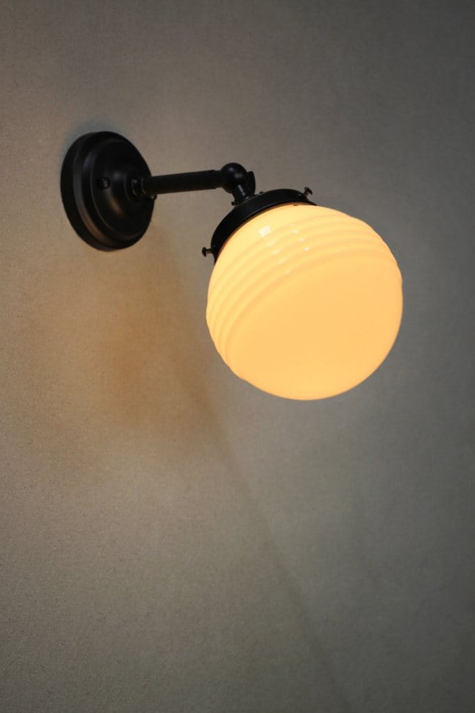 Small black adjustable wall light with ridged opal shade