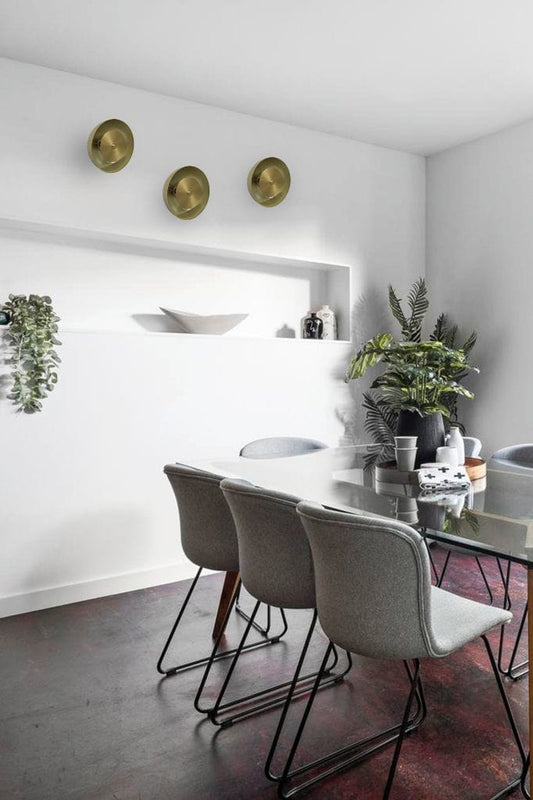 Gold dome disc wall lights in dining room space