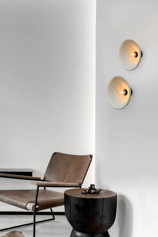 Ceramic wall lights installed above chair