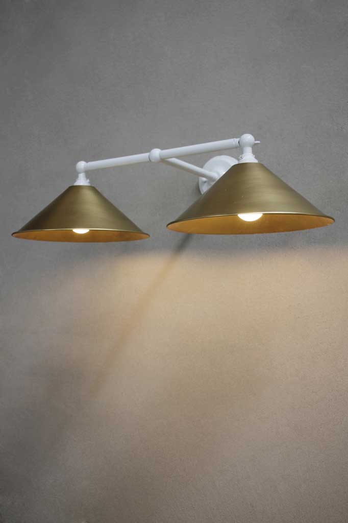 White wall sconce with bright brass shades