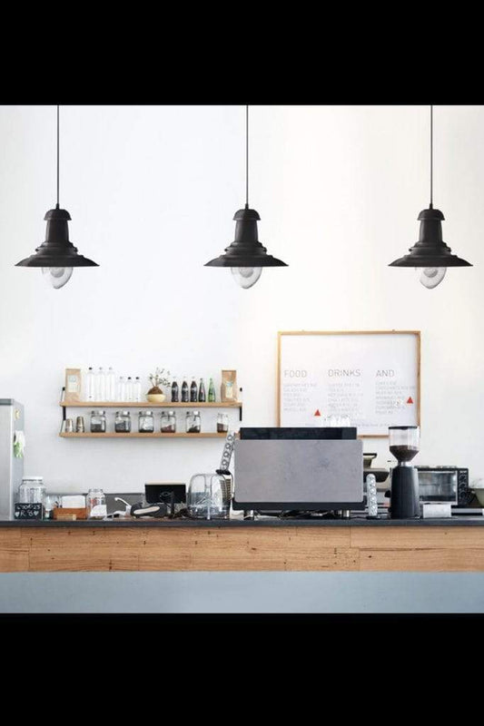 Three black nautical pendants over a counter