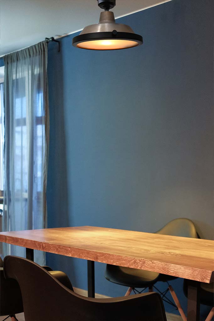 Bright brass flush mount with flat frosted cover over dining table.