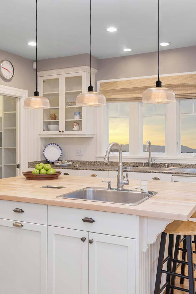 glass pendant lights over white kitchen island