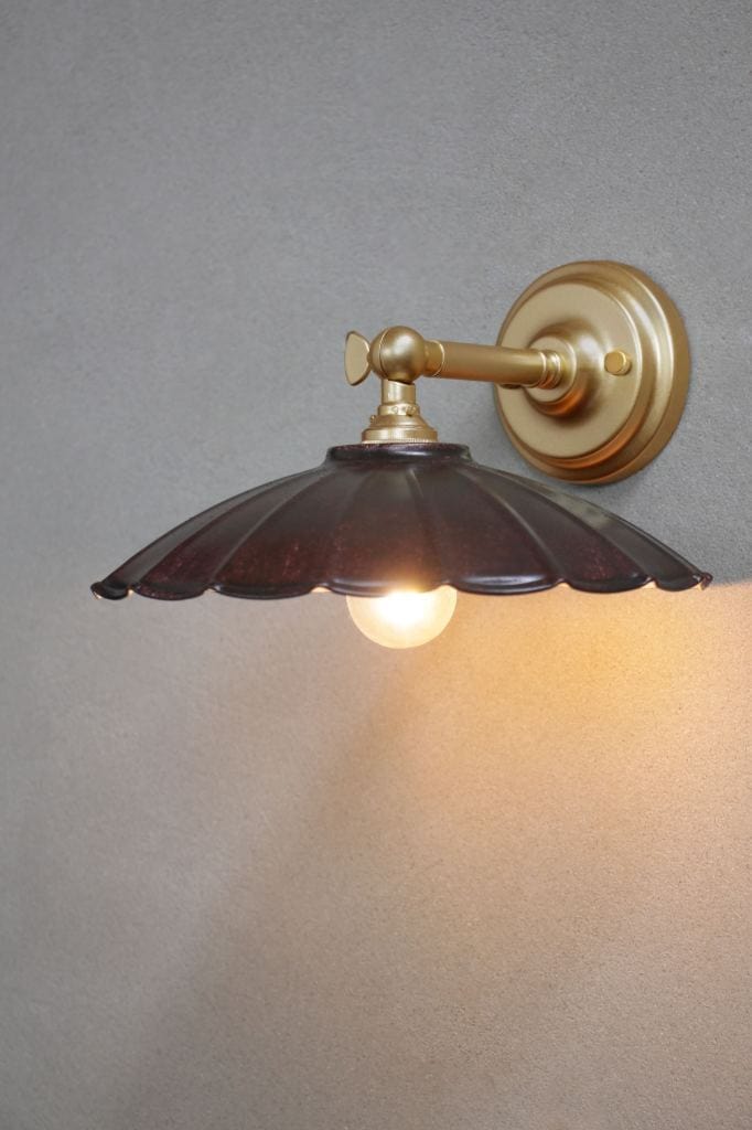 Small black umbrella shade on a gold/brass wall sconce. 