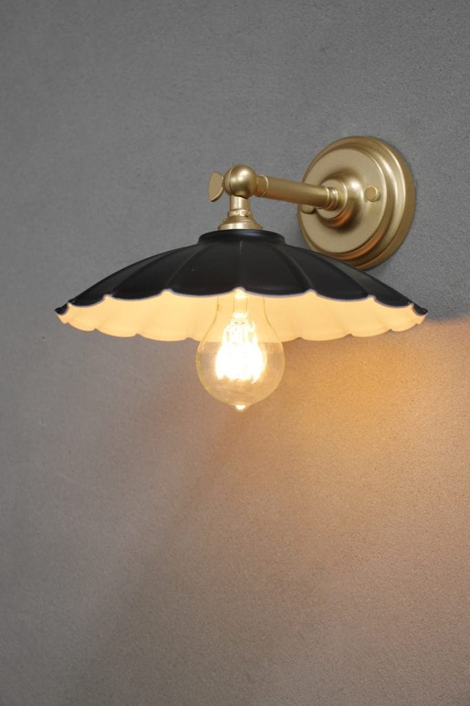 Small black umbrella shade on a gold/brass wall sconce. 