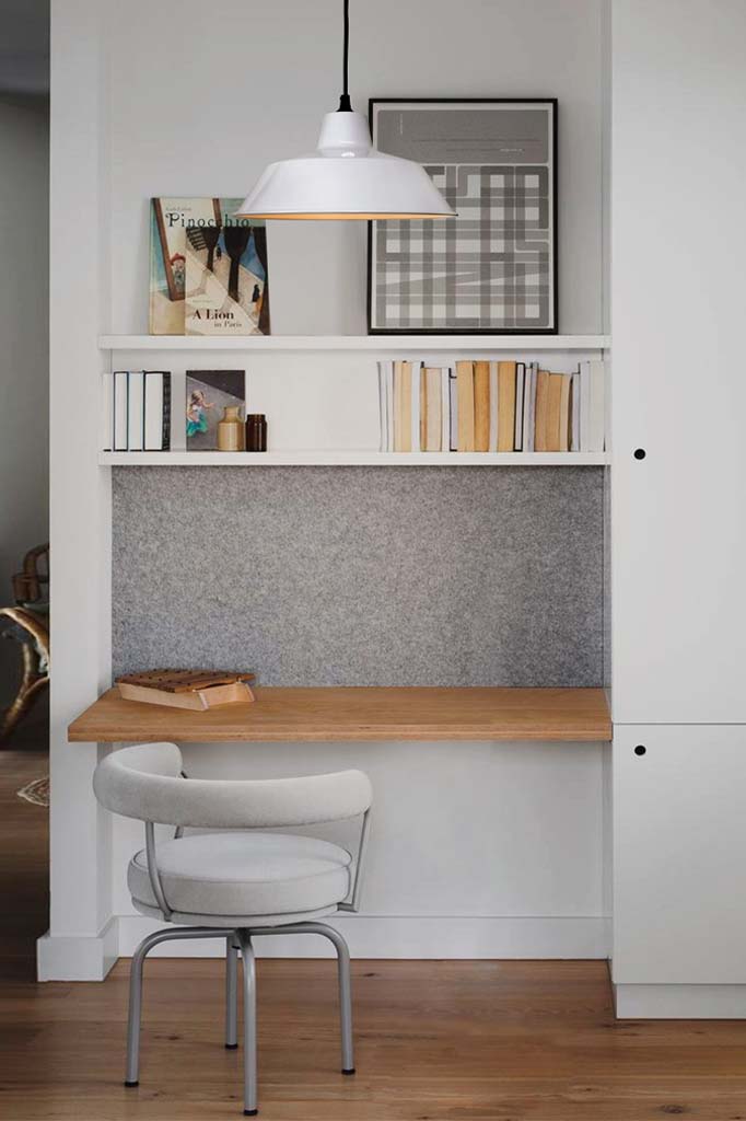 White shade with black cord over desk.