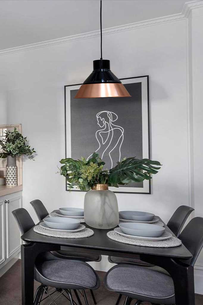 Bright copper shade with black cover over dining table