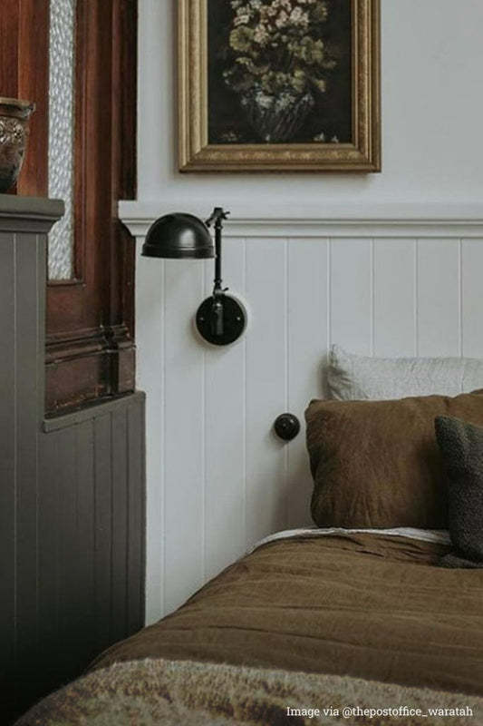 industrial wall lamp next to the bed.